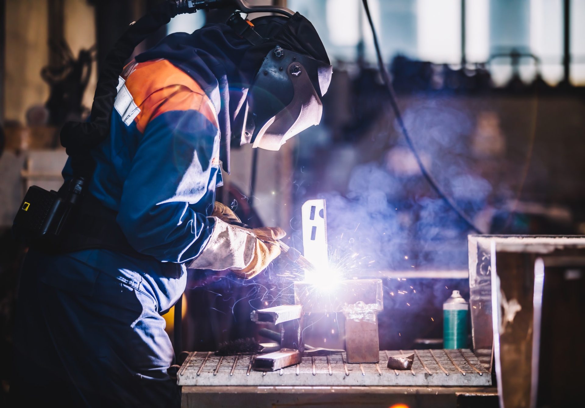 worker welding in oxygen mask in a factory e1638173195855